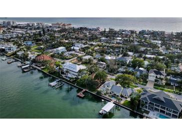 Stunning aerial view of waterfront homes with boat docks along the beach with gulf views at 761 Bay Esplanade, Clearwater Beach, FL 33767