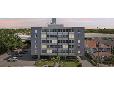 Multi-story Suncoast Towers building featuring a gray exterior, ample windows, and covered parking at 841 4Th N Ave # 55, St Petersburg, FL 33701