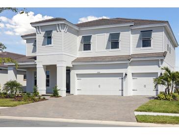 Beautiful two-story home featuring a spacious three-car garage and attractive modern architectural details at 10320 Longmeadow Ave, Parrish, FL 34219