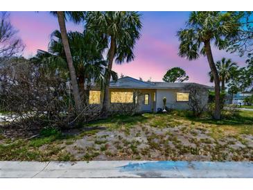 Charming single-story home surrounded by lush palm trees and a twilight sky at 123 14Th Ave, Indian Rocks Beach, FL 33785