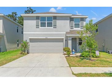 Charming two-story home with a two-car garage and well-maintained landscaping at 13765 Whiskey Daisy Dr, Dade City, FL 33525