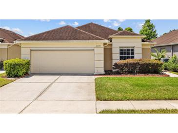 Charming single-story home with a two-car garage, well-maintained lawn, and manicured landscaping at 26338 Whirlaway Ter, Wesley Chapel, FL 33544