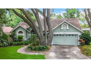 Charming single-story home with a well-manicured lawn, mature trees, and two-car garage at 2973 Spring Oak Ct, Palm Harbor, FL 34684