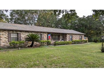 Charming brick home featuring a well-maintained lawn and lush landscaping at 3705 Bruton, Plant City, FL 33565