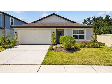 Charming single-story home with a well-manicured lawn, attached garage, and a welcoming front entrance at 3935 Capri Coast Dr, Plant City, FL 33565