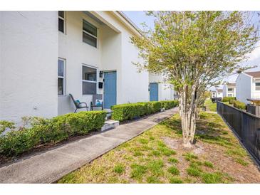 Charming townhome exterior with blue door, quaint patio seating, and fresh landscaping at 4314 La Mora Ct, Tampa, FL 33611