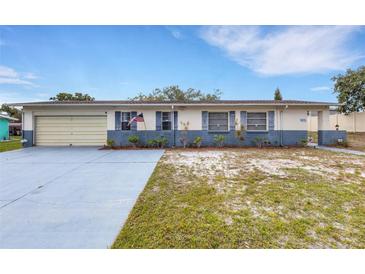Charming single-story home with an attached garage, driveway, and an American flag displayed out front at 5250 Brody Blvd, Wimauma, FL 33598