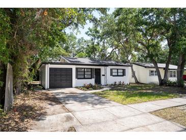 Charming single-story home boasts a black and white exterior, modern landscaping, and a well-maintained front yard at 8059 26Th N Ave, St Petersburg, FL 33710