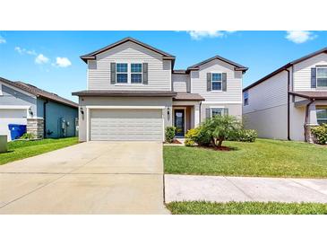 Charming two-story home with a well-maintained lawn and two-car garage at 9293 Rally Spring Loop, Wesley Chapel, FL 33545