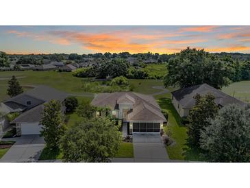 Beautiful aerial view of home with lush landscaping and sunset sky at 13238 Chipout Ln, Hudson, FL 34669