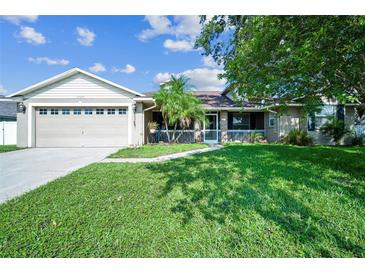 Charming home featuring a lush lawn, a screened-in porch, and an attached two-car garage at 2507 Dewberry St, Valrico, FL 33596