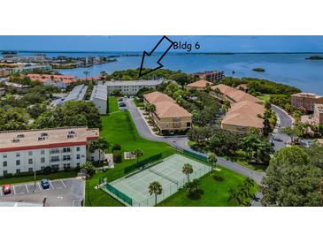Scenic aerial view of condo community with lush landscaping, tennis court, and waterfront access at 2700 Bayshore Blvd # 5210, Dunedin, FL 34698