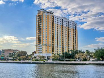 Stunning exterior shot of a luxury high-rise building with waterfront views and blue skies at 345 Bayshore Blvd # 1813, Tampa, FL 33606