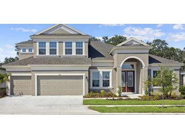 Charming two-story home with a manicured lawn and a two-car garage. It has a modern design and a welcoming entrance at 5116 Wildwind Dr, Apollo Beach, FL 33572