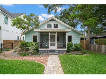 Charming light blue single-Gathering home featuring a screened-in front porch and a well-maintained, landscaped front yard at 535 31St N Ave, St Petersburg, FL 33703