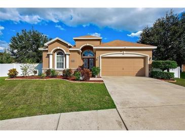 Charming one-story home with manicured lawn, flower beds, neutral paint, and a two-car garage at 6519 Twin Bridges Dr, Zephyrhills, FL 33541