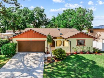 Charming single-story home with a well-manicured lawn and a spacious driveway leading to an attached two-car garage at 8315 W Elm St, Tampa, FL 33615