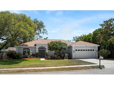 Charming single-story home featuring a well-manicured lawn, double front doors, and attached two-car garage at 970 Ridgewood Ter, Tarpon Springs, FL 34689