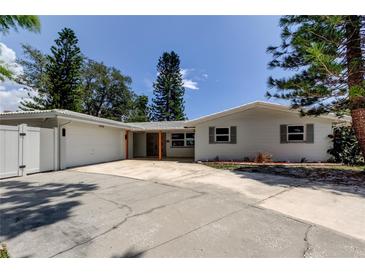 Charming single-story home with a wide driveway, lush trees, and welcoming curb appeal at 10744 Drummond Rd, Tampa, FL 33615