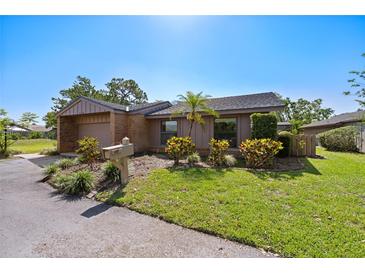 Charming single-story home with a brick exterior, attached garage, and a well-manicured front yard with a palm tree at 6101 Willow Oak Cir, Bradenton, FL 34209