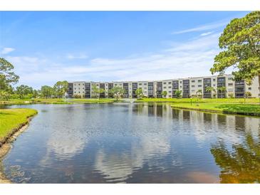 Beautiful exterior view of a condo community surrounding a scenic lake with a fountain at 6188 80Th N St # 101, St Petersburg, FL 33709