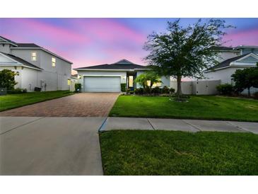 Beautiful single-Gathering home with manicured lawn, brick driveway, and attached two car garage at 751 Cajeput Loop, Tarpon Springs, FL 34689
