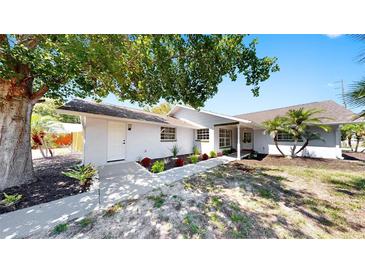 Charming single-story home featuring a well-maintained front yard, beautiful landscaping, and a welcoming entrance at 829 Riverside Dr, Tarpon Springs, FL 34689