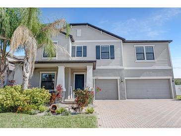 Beautiful two-story home featuring a three-car garage, landscaped yard, and a welcoming front porch at 11726 Sunburst Marble Rd, Riverview, FL 33579