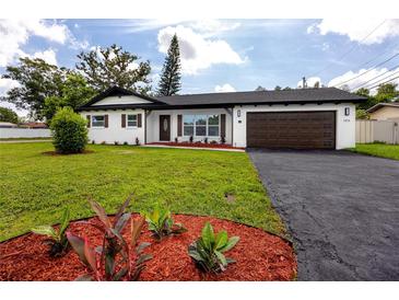 Charming single-story home with a well-maintained lawn, black asphalt driveway, and manicured landscaping at 1873 Murray Ave, Clearwater, FL 33755