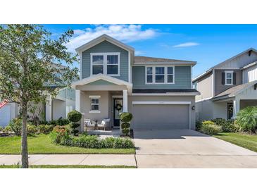 Charming two-story home with a covered front porch and a well-manicured lawn with garden at 28809 S Orange Berry S Dr, Wesley Chapel, FL 33543