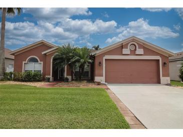 Charming single-story home with manicured lawn, brick walkway, and two-car garage at 29650 Eagle Station Dr, Wesley Chapel, FL 33543