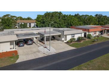 Well-maintained exterior featuring a carport, landscaped garden, and an American flag at 4039 La Pasida Ln, New Port Richey, FL 34655