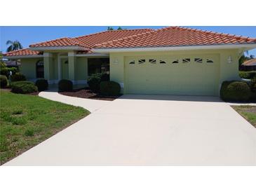 Charming single-story home with a red tile roof and well-maintained landscaping at 405 Lemonwood Dr, Englewood, FL 34223