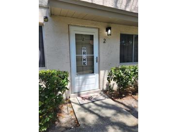 Charming front door with welcome mat and decorative signage near well-maintained landscaping at 1833 Bough Ave # 2, Clearwater, FL 33760