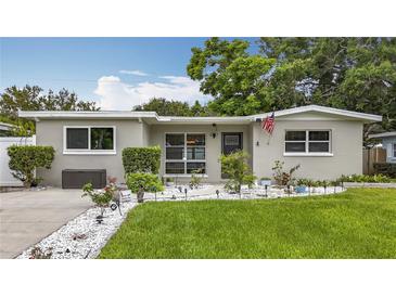 Charming single-story home with well-manicured lawn and garden pathway at 1921 Ridgewood Dr, Clearwater, FL 33763