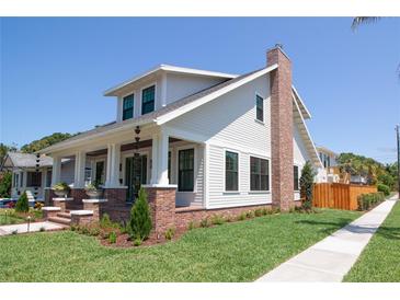 Charming two-story home featuring a welcoming front porch, brick accents, and lush green lawn at 2101 3Rd N Ave, St Petersburg, FL 33713