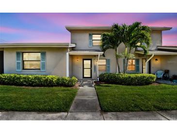 Charming home exterior with lush landscaping, blue shutters, and a welcoming walkway to the front door at 2131 Ridge S Rd # 3, Largo, FL 33778