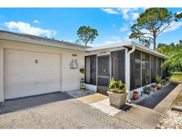 Charming home featuring an attached garage, a screened-in porch, and well-maintained landscaping at 3229 40Th S Ln # C, St Petersburg, FL 33711