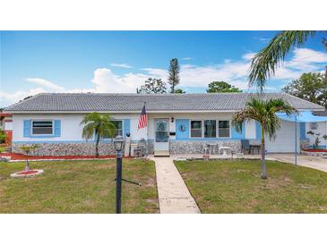 Charming single-story home with well-manicured lawn, stone accents, and beautiful blue shutters on a bright, sunny day at 6350 18Th N Ave, St Petersburg, FL 33710