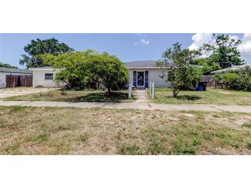 Modest single-story home featuring a charming entrance and mature trees in a tranquil front yard at 1242 Bermuda St, Clearwater, FL 33755