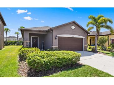 Charming single-story home featuring a well-manicured lawn and a two-car garage at 1321 Custer Bayou St, Ruskin, FL 33570