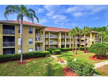 Well maintained condo complex with lush landscaping, benches, and palm trees offering a relaxing environment at 2690 Coral Landings Blvd # 217, Palm Harbor, FL 34684
