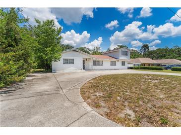 Quaint two-story home featuring a spacious front yard and a long driveway at 311 Jeanal Pl, Tampa, FL 33612
