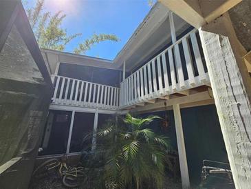 Exterior view of a two-story home featuring screened in balconies and a landscaped courtyard at 32348 Marchmont Cir, Dade City, FL 33523