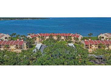 Panoramic aerial view of waterfront condos with red tile roofs, lush landscaping, and stunning water views at 7520 Sunshine Skyway S Ln # 109, St Petersburg, FL 33711
