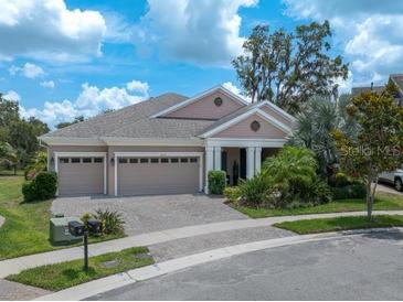 Charming single-story home featuring a three-car garage and tropical landscaping at 14223 Lambert Bridge Ln, Lithia, FL 33547