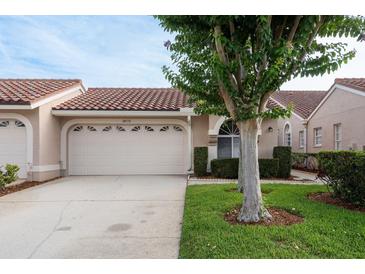 Charming home featuring a well-manicured lawn and a spacious two-car garage, complemented by a stylish red-tiled roof at 3875 Darston St, Palm Harbor, FL 34685