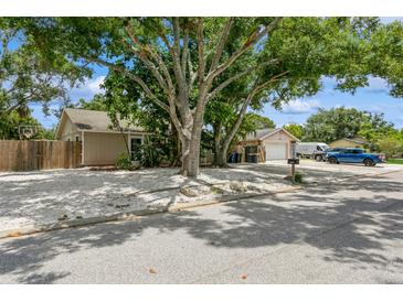 Charming single-story home featuring a gravel yard, mature trees, and detached garage at 4021 Vana Dr, Sarasota, FL 34241