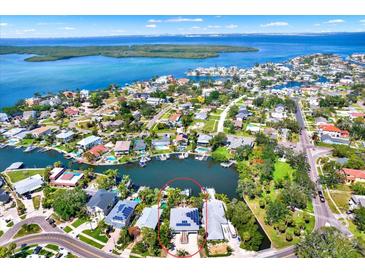 Panoramic aerial view of waterfront home with solar panels, dock, and lush landscaping on a sunny day at 5331 Bayou Grande Ne Blvd, St Petersburg, FL 33703