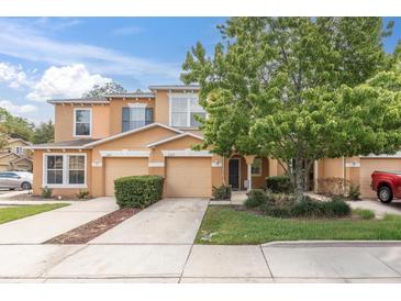 Charming townhome showcases a well-maintained lawn, lovely tree, and inviting facade at 11615 Mango Ridge Blvd # 39, Seffner, FL 33584